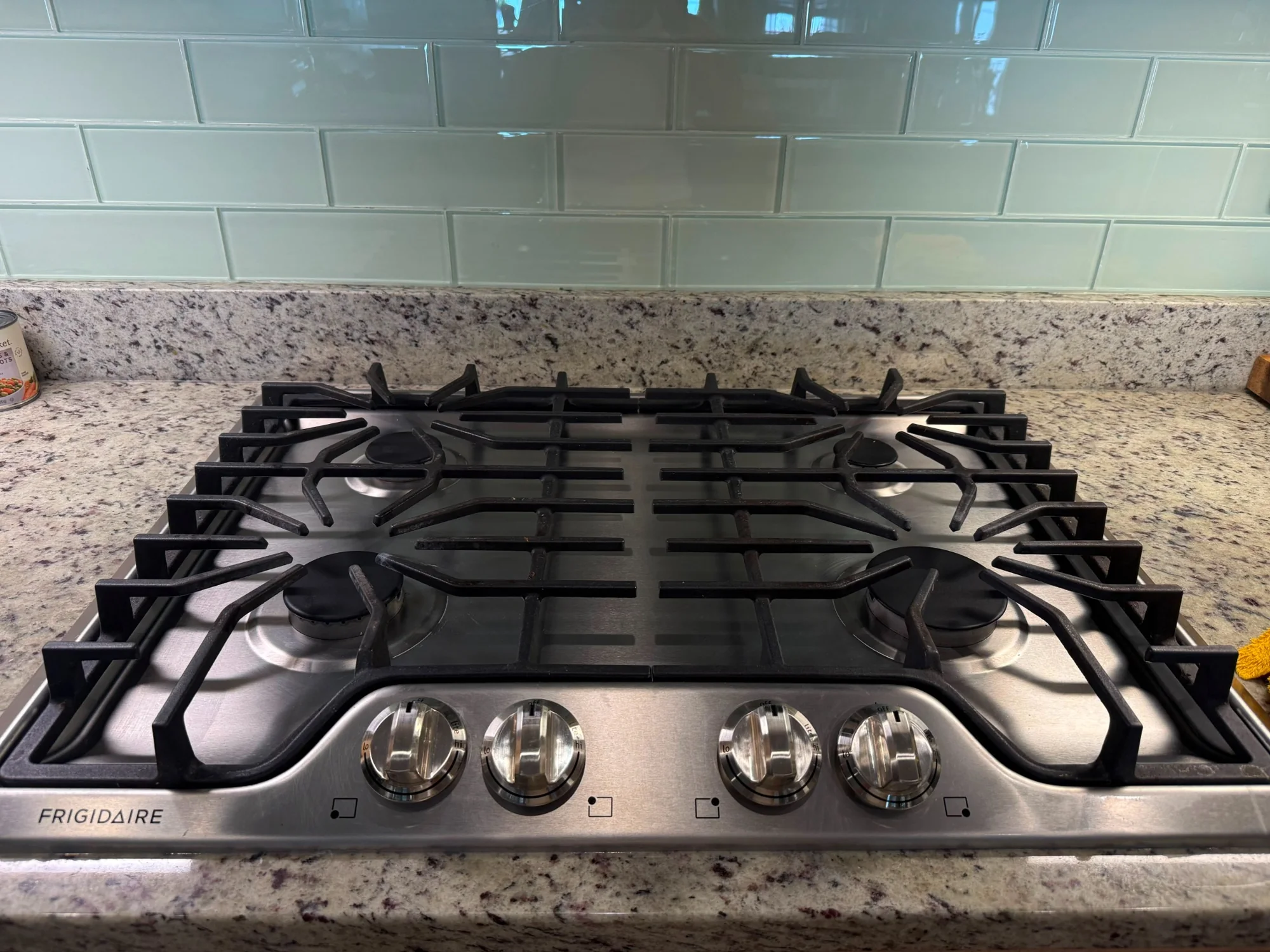 Close-up of a professionally cleaned stainless steel gas cooktop